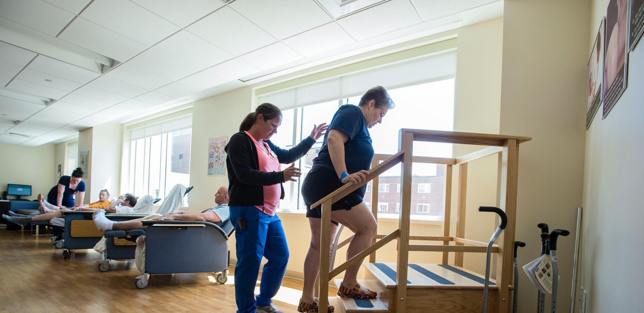 Physical therapist assists a patient as she practices climbing stairs after knee replacement at Cooley Dickinson Medical Group Orthopedics & Sports Medicine, West Hatfield, MA 01088.