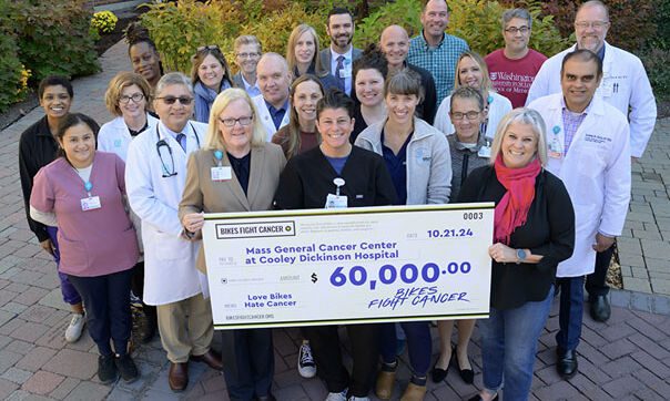 A group of Cooley Dickinson staff holding a large donation check