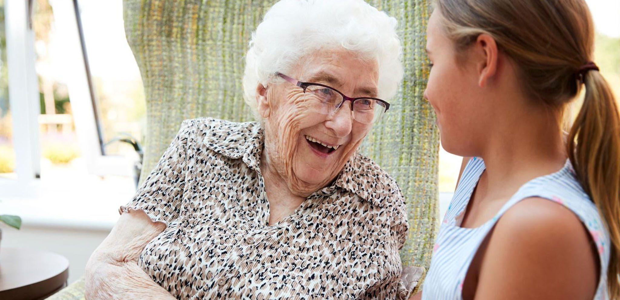 Senior woman smiling at young female teenager