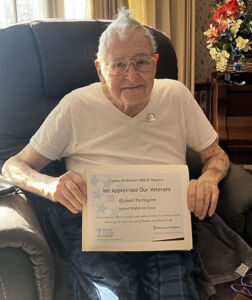 Senior patient holding a certificate for his service in the armed forces